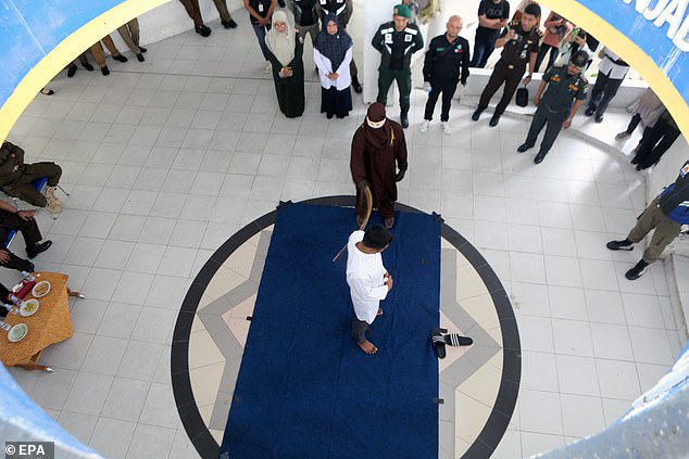 A man has been brutally caned 42 times for consuming alcohol and violating Sharia law on the Indonesian island of Sumatra. Pictured: A man is caned in Banda Aceh, Indonesia