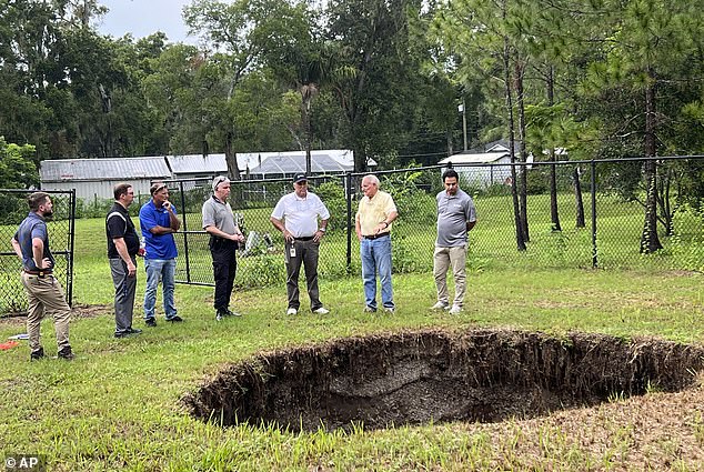 This photo shows a sinkhole that fatally swallowed a sleeping man in his own home in 2013. The sinkhole has reopened for the third time, this time behind a chain-link fence and with no damage to people or property.