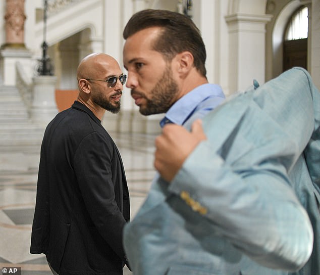 Andrew Tate and his brother Tristan are banned from leaving Romania after an appeals court overturned an earlier ruling allowing them to travel within the EU. Pictured: Andrew Tate, left, and his brother Tristan wait inside the Court of Appeal in Bucharest, Romania, Tuesday, July 16, 2024