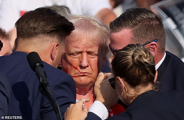 A barrage of shots was fired at a political rally in Pennsylvania, with one bullet grazing the ear of second-place presidential candidate Donald Trump (pictured)