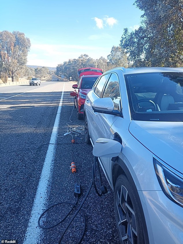 The image, posted to Reddit on Monday, shows two electric vehicles parked behind each other along a highway in rural Australia and connected by charging cables.