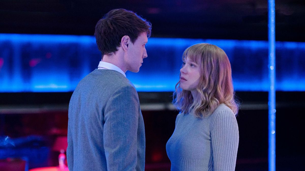 Gabrielle (Léa Seydoux) and Louis (George MacKay), a pale man and woman in light blue-gray sweaters, stand face to face, looking into each other's eyes in an abstract neon blue space in a scene from The Beast