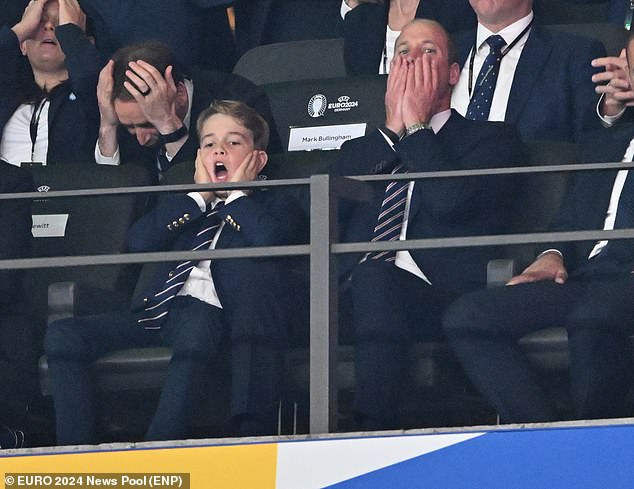 Prince George covers his face with his father Prince William as they watch England lose the Euro 2024 final to Spain in Berlin