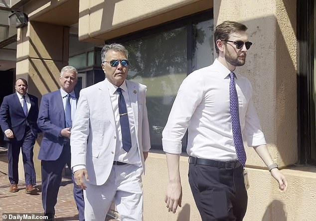 Rep. Mark Takano, D-Cali., (second from right) keeps a serious face as he ignores questions from reporters after the crucial meeting