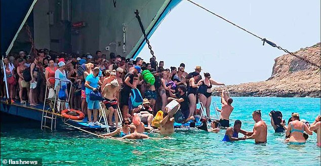 Hundreds of terrified tourists are forced to disembark from their ferry into the sea and slowly wade through neck-deep water to reach a natural beauty spot in Balos, Crete