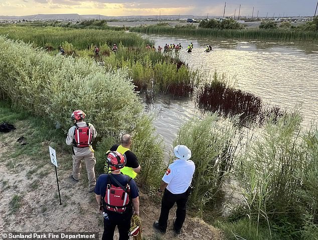 Rescue workers watch as a dive team dives into the Rio Grande River near El Paso, Texas, to pull 54 illegal immigrants from the water Tuesday afternoon