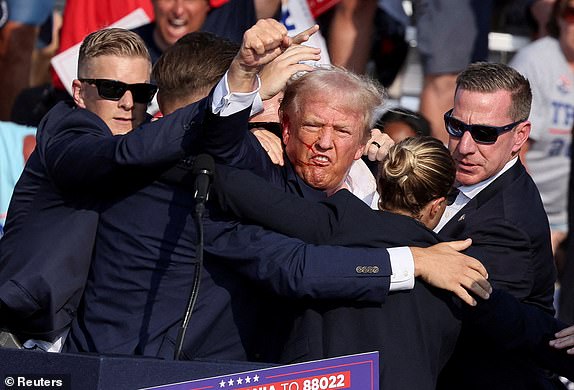 ARCHIVE PHOTO: Republican presidential candidate and former U.S. President Donald Trump gestures with a bloodied face as he is assisted by U.S. Secret Service personnel after he was shot in his right ear during a campaign rally at the Butler Farm Show in Butler, Pennsylvania, U.S., July 13, 2024. REUTERS/Brendan McDermid/File photo