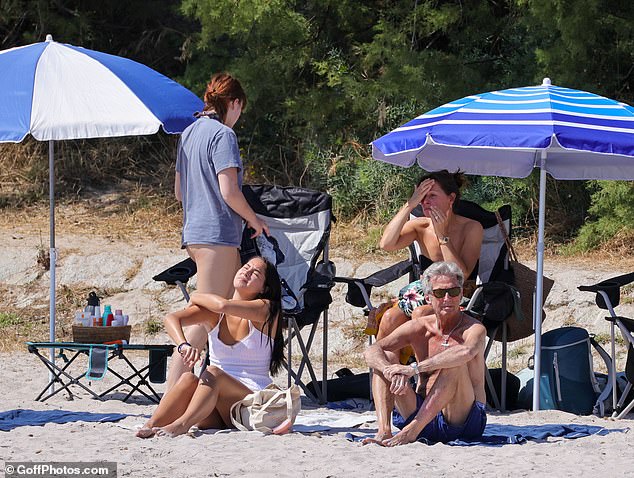 The £450million megastar, who is regarded as one of the greatest guitarists of all time, relaxed on the beach with his daughters and wife Melia
