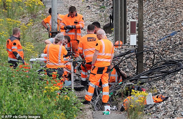 SNCF employees inspect the scene of a suspected attack on the high-speed network in Croiselles, northern France, on July 26, 2024