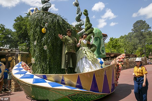 Actors dressed as Princess Tiana and Prince Naveen from The Princess and the Frog perform on a float during the Festival of Fantasy Parade