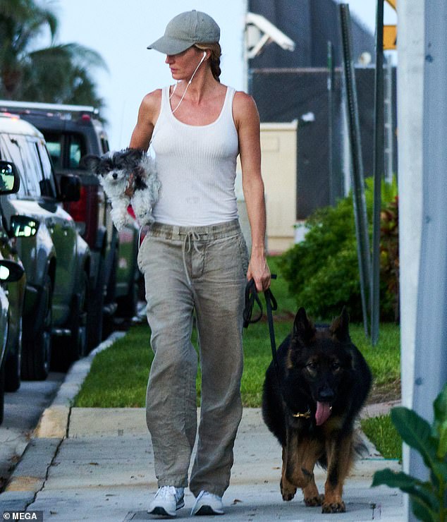 Gisele Bundchen stepped outside with her big, brown dog on a leash and her little black and white dog, Fluffy, in her other hand