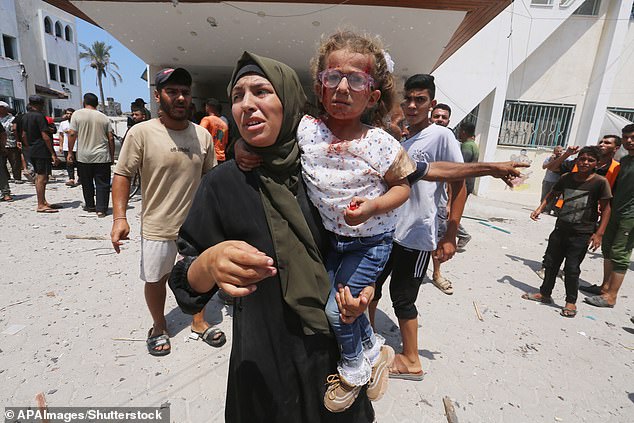 Palestinians flee a school they sought refuge in on Saturday after it was hit by an Israeli attack in Deir el-Balah in the central Gaza Strip, amid the ongoing conflict between Israel and the Palestinian militant group Hamas