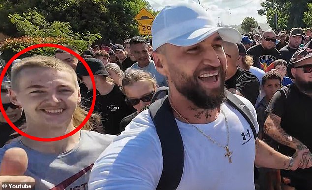 Jacob Neil Armstrong, 20, (circled) has been charged in connection with a chaotic rally in Logan for rapper Spanian (pictured right)