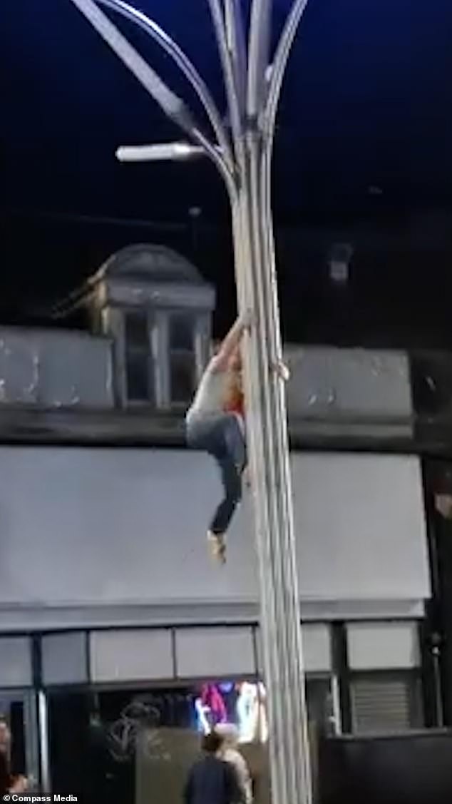 The man in the glasses was spotted climbing over the designed metal street lamp in Sauchiehall Street, Galsgow, on Sunday evening after the 2024 European Championship final