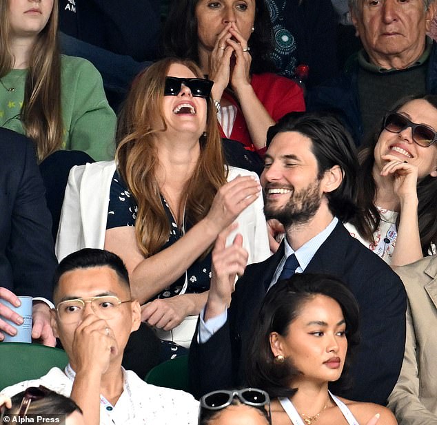 Isla Fisher looked cheerful as she laughed and joked while sitting in the stands at the All England Lawn Tennis and Croquet Club for the eighth day of Wimbledon