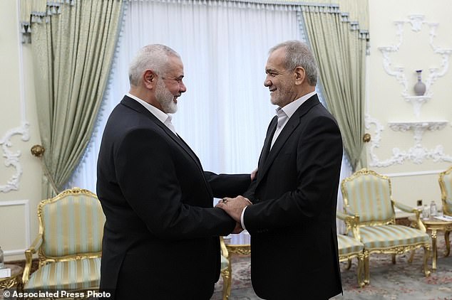 In this photo released by the Iranian presidential office, President Masoud Pezeshkian (right) shakes hands with Hamas leader Ismail Haniyeh at the start of their meeting at the president's office in Tehran, Iran, Tuesday, July 30, 2024. (Iranian presidential office via AP)