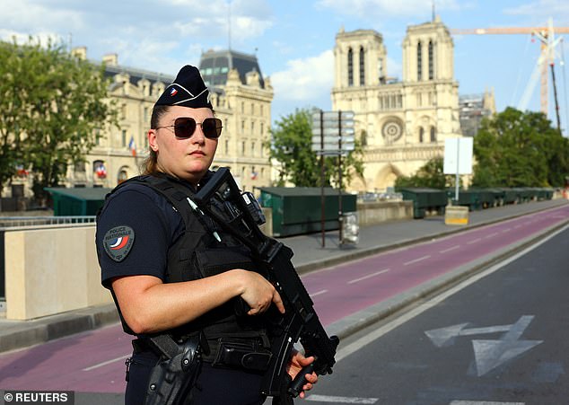 Israel has deployed armed Shin Bet officers to protect 88 Israeli athletes and their staff at the Paris Olympics. Pictured: A police officer stands guard at Notre Dame Cathedral as the security perimeter is set up for the opening ceremony of the Paris 2024 Olympic Games.