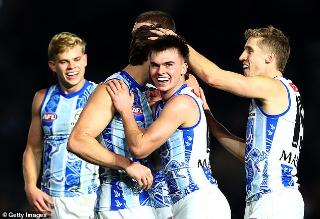 North Melbourne players celebrate their thrilling win over the Gold Coast Suns