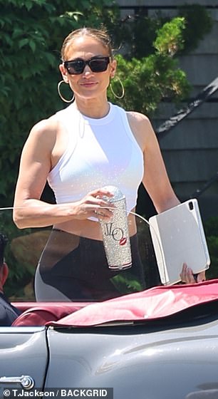 The Atlas producer wore a white halter top with black leggings as she held a laptop and her enchanting JLo cup