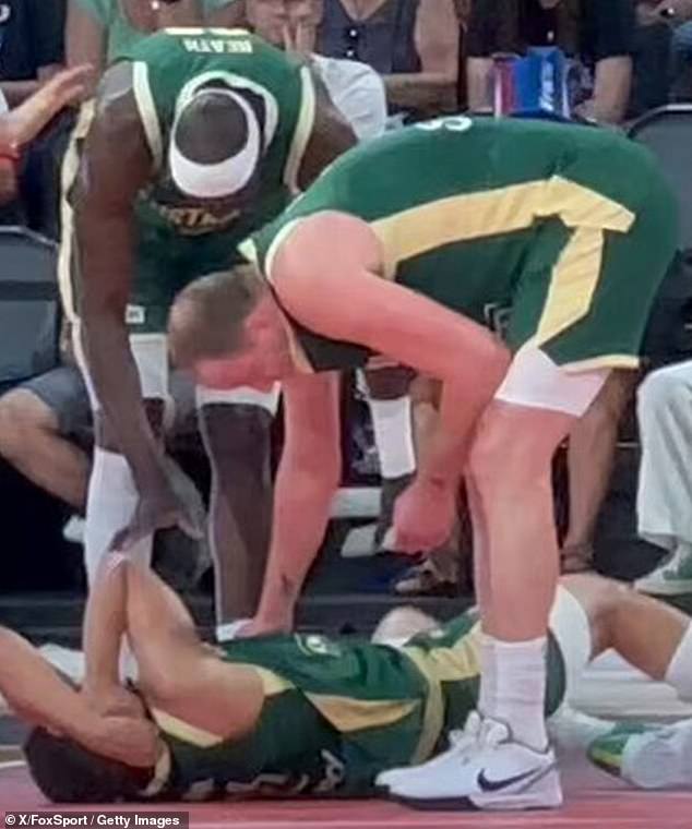 Australians Duop Reath and Joe Ingles take care of Dante Exum after he suffers a neck injury