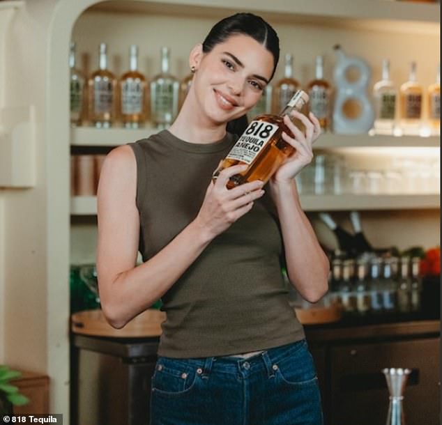 Kendall Jenner enjoyed herself behind a bar on National Tequila Day, which fell on Wednesday. The reality star went braless as she wore an army green tank top that showed off her toned arms, while she wore tight blue jeans