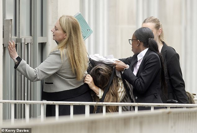 Lauryn Goodman hid from the cameras under a coat today as she arrived at court