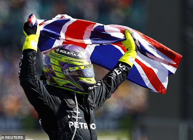 Lewis Hamilton pictured holding the Union Jack aloft after winning the British Grand Prix on Sunday