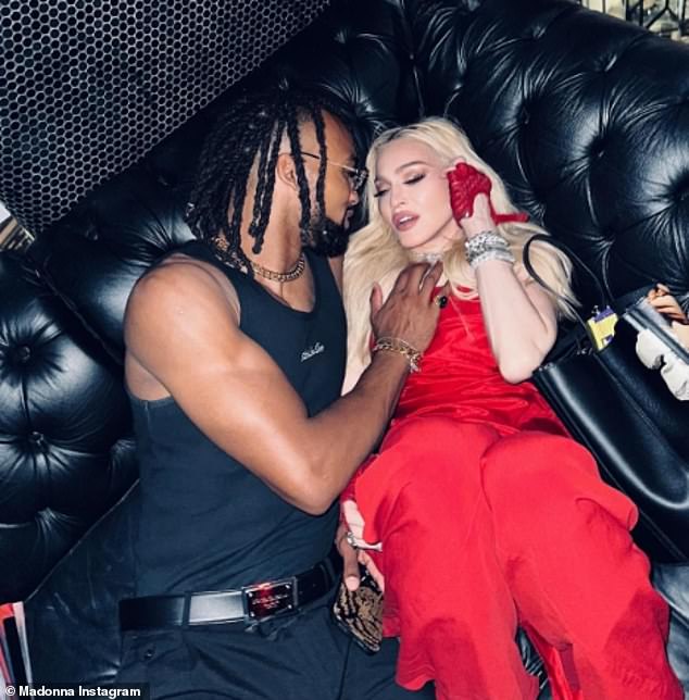 Madonna put on an amorous show with a handsome younger man on July 4 as she remembered the first anniversary of her near-death health scare