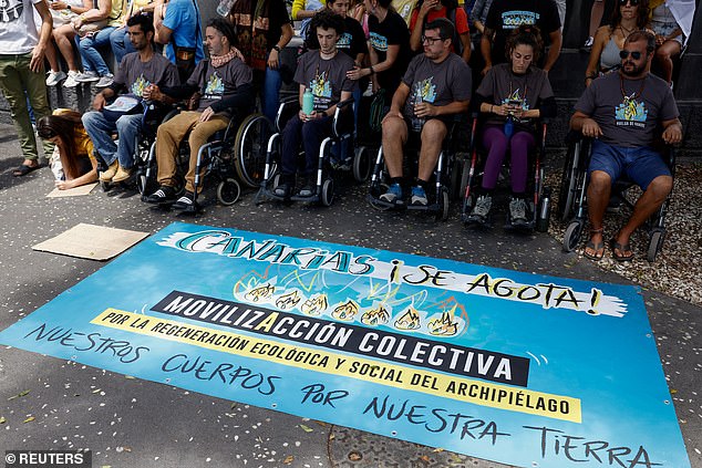 People on hunger strike sit in wheelchairs during a protest for a change in the tourism model in the Canary Islands, in Santa Cruz de Tenerife, Spain, in April