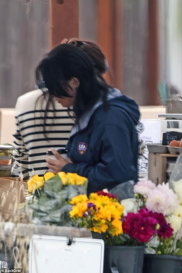Meghan Markle (pictured in a striped top) was spotted picking up supplies at a farmers market in Montecito before hopping into a car and driving away