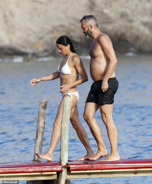 Michelle Rodriguez showed off her incredible figure in a skimpy white bikini bottom as she strolled around Ibiza with a male companion on Sunday