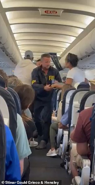 Terrell Davis is escorted off a plane by an FBI agent