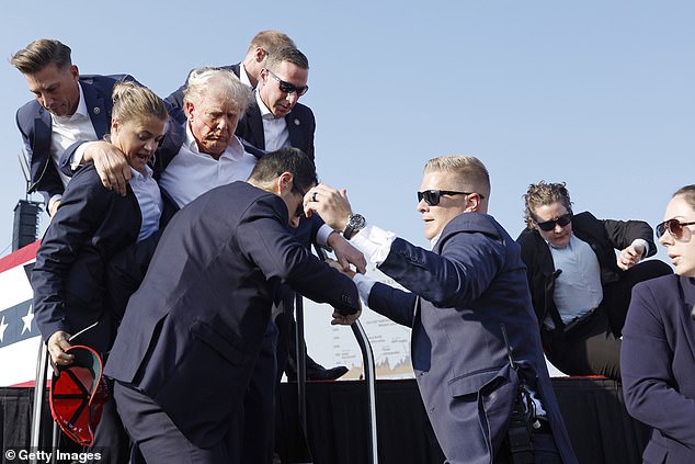 Republican presidential candidate and former President Donald Trump is led off the stage during a rally on July 13, 2024