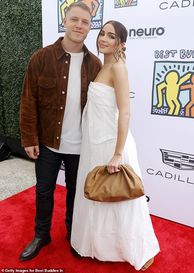 Christian McCaffrey, 28, stood up for his wife, Olivia Culpo, 32, after a style influencer described her Dolce & Gabbana wedding dress as 'nothing' and 'no personality'; seen in LA in 2023
