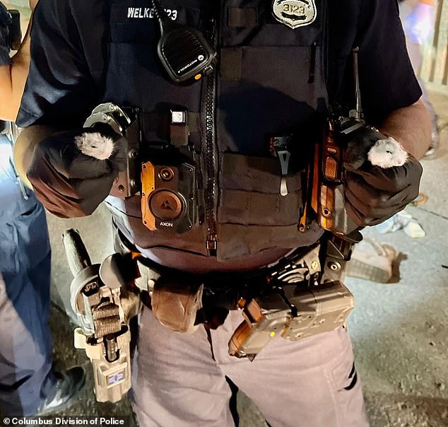 A Columbus police officer is seen holding the two hamsters found in Pancake's pockets