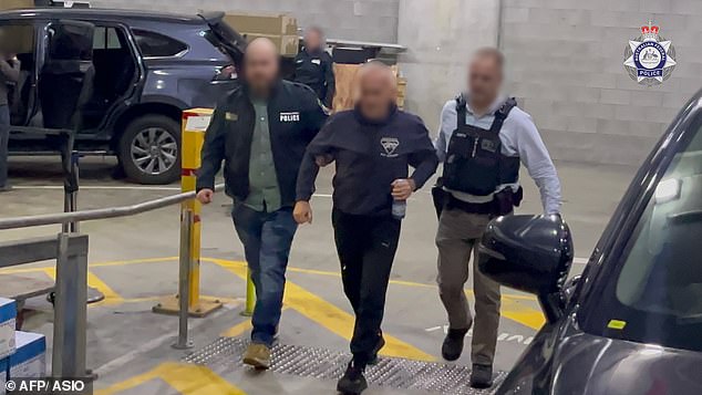 Two Russian-born Australians, Kira Korolev, 40, and her husband Igor (pictured centre), 62, were arrested in dramatic scenes on Thursday over an alleged espionage plot targeting the Defence Ministry.