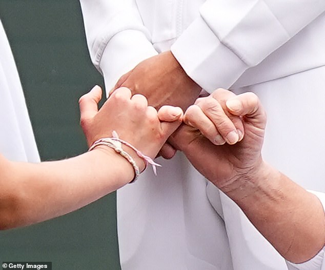 In a sweet moment, the nine-year-old royal intertwined her pinky fingers with the wheelchair tennis player