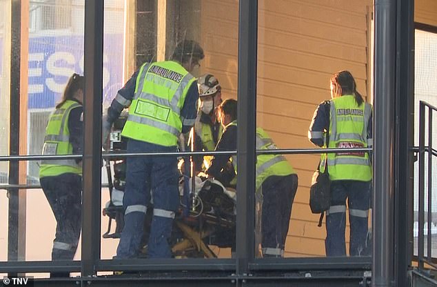 A team of paramedics performed CPR on the woman as she was escorted through the train station after she allegedly climbed onto the tracks to retrieve an object she had dropped