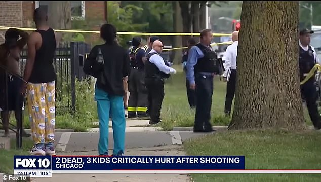 Officers and bystanders are pictured on a street where a horrific massacre took place in which an 8-year-old boy was killed, along with two family members, while two other boys, aged 5 and 7, were injured in the same shooting.