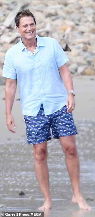 Beaming from ear to ear, Rob later dipped his toes in the water, dressed in a light blue shirt.