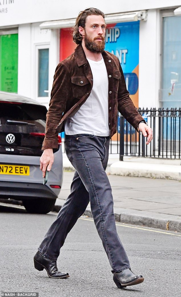 Aaron, 33, looked casual in blue jeans which he paired with a white T-shirt and a brown suede jacket