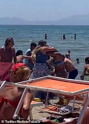 Women are seen pulling each other's hair and struggling to win the fight as the audience watches helplessly.