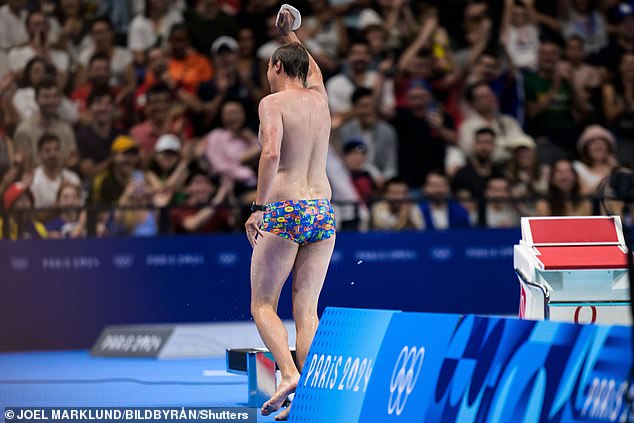 A man dressed in tight, colorful swimming trunks waves to fans after emerging from the Olympic swimming pool at the Paris La Defense Arena on Sunday morning.