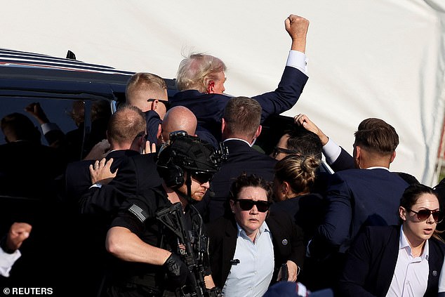 Secret Service personnel escorted a defiant Trump into a vehicle after he was injured