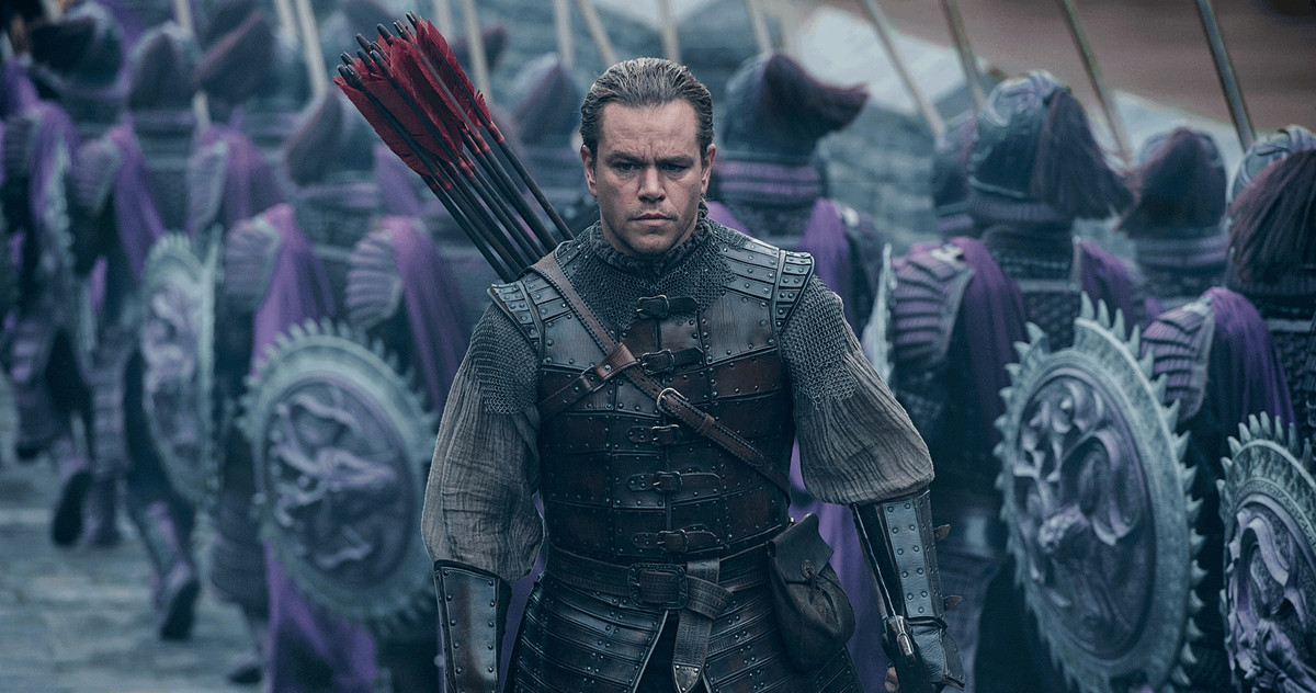 Matt Damon, with arrows on his back, walks past a group of soldiers in purple armor in The Great Wall