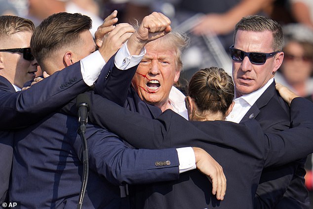 Republican presidential candidate and former President Donald Trump is helped off the stage by U.S. Secret Service agents during a campaign rally in Butler, Pennsylvania, on Saturday, July 13