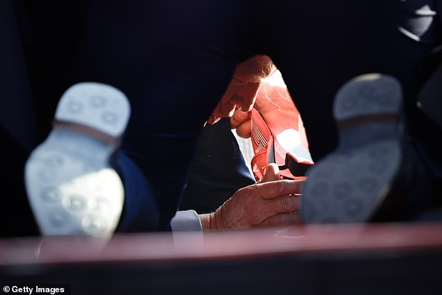 An extraordinary photo shows Donald Trump on the ground at Butler Show Grounds in Pennsylvania on Saturday after he was injured in a shooting that left two people dead