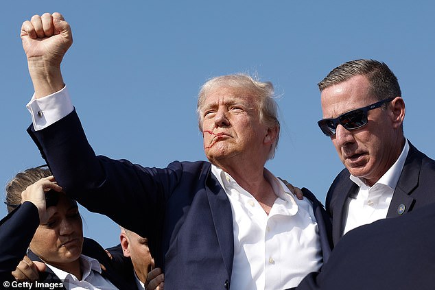 Donald Trump is pictured with blood on his face moments after shots were fired at a rally in Butler, Pennsylvania, on Saturday