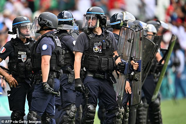 Riot police were pictured after Moroccan fans stormed the pitch following Argentina's final goal