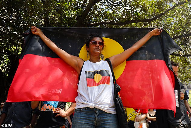 Victoria is one step closer to becoming the first state to sign a treaty with Indigenous Australians (pictured, a protester holds the Aboriginal flag at an Invasion Day rally in Sydney)